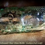 embossed bottle, clear glass, fruit motif